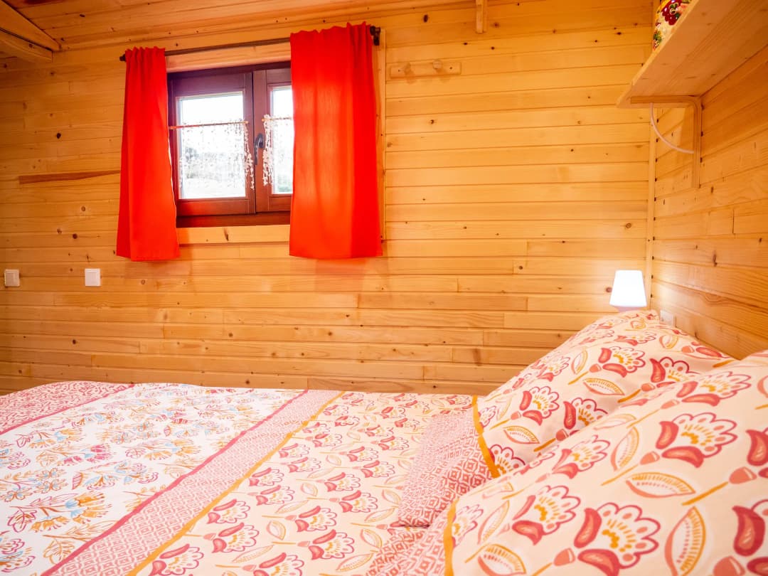 Vue du lit principal avec rideaux rouges