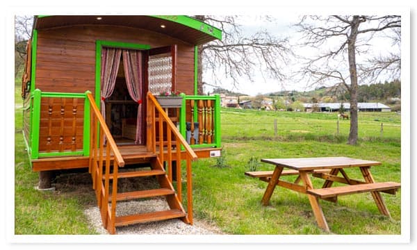 Hébergement insolite en roulotte en bois avec table de jardin