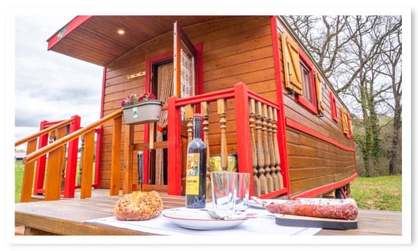 Hébergement insolite en roulotte en bois avec table de jardin