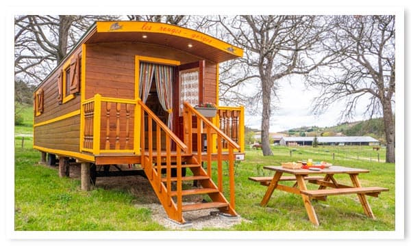 Hébergement insolite en roulotte en bois avec table de jardin